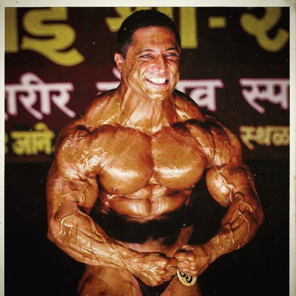 Representative image of Kaizzad Capadia flexing on stage to show his hypertrophy